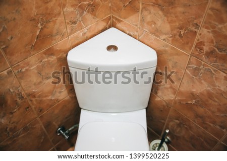 White toilet tank in the triangle shape. Bathroom in the hotel or at home.