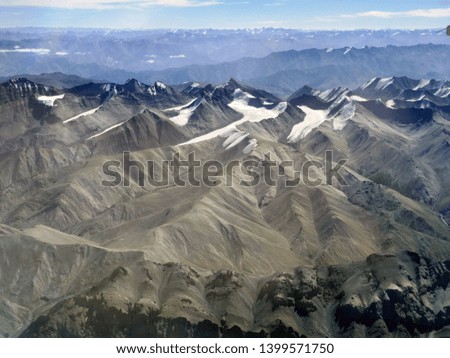 Bird's-eye view of the Himalayan mountains partially covered with snow in India