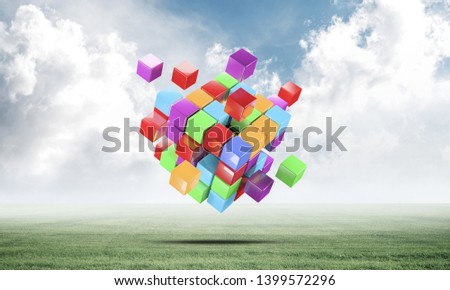 Abstract colorful cubes on green meadow. Digital technology and innovation solutions. New approach to business management. Nature landscape with green grass and blue sky. Mixed media with 3D object