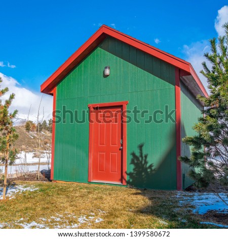 Clear Square Small storage shed on grassy terrain with trees and powdery snow