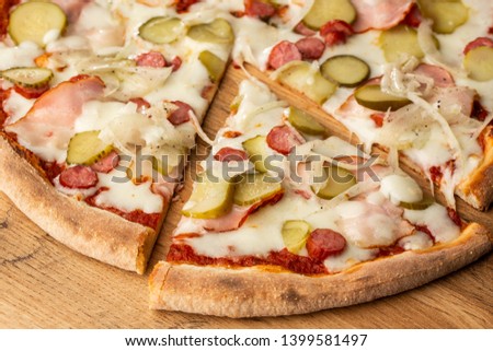 Pizza with ham and tomatoes. Pizza with pickles and onion. Stuffing of ham and cucumbers. Delicious fast food. Junk food. Delicious food. Pizza on wooden background