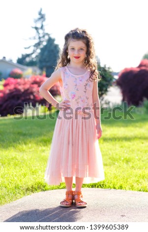 Portrait of a five year old girl wearing makeup and a pretty dress before a dance performance at a ballet.