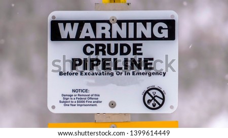 Panorama Close up of a Warning sign on an area with crude pipeline viewed in winter