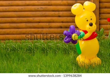 A large yellow bear from balloons with a big flower in the garden, Congratulations on the occasion