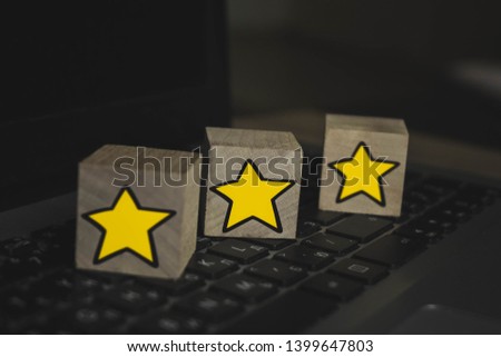 wooden cubes which depict 3 stars lying on a laptop