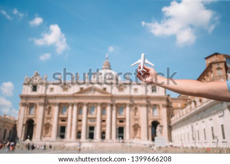 Closeup toy airplane on St. Peter's Basilica church in Vatican city background. Concept of travel imagination