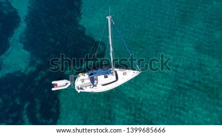 Aerial photo of luxury yacht - sail boat cruising in deep blue waters of Santorini island, Cyclades, Aegean, Greece