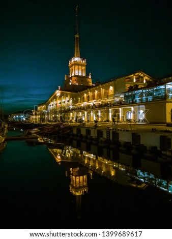 The building of the Sochi seaport at night in the reflection of the sea