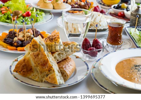 Traditional Turkish Ramadan,iftar dinner table with soup,chicken,rice,salad,dry and fresh fruits and sliced Ramadan Bread.