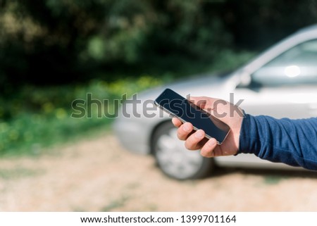 Man using a mobile phone on car background, closeup image of social media, communication technology and busy lifestyle