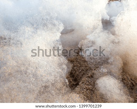 Closeup abstract photo of soap foam lying on sandy sea beach after beach disco party