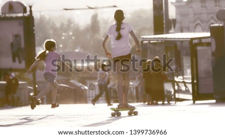 two girls actively riding and running into the street. children's recreation and entertainment

