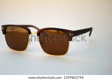 brown glasses in a beautiful frame on a cream background