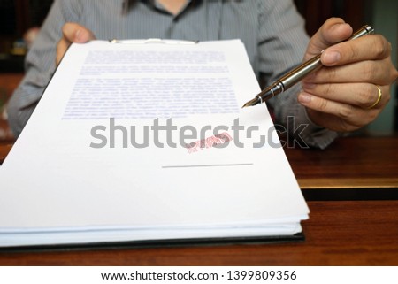 Close-up pictures of the hands of businessmen signing and stamping in approved contract forms