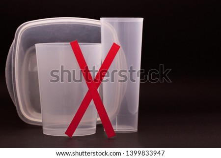 Plastic dishes. Rejection of plastic. Ban plastic. Ecology. Plastic cup on a black background. Recycling. Eco-friendly material. Contamination of the environment.