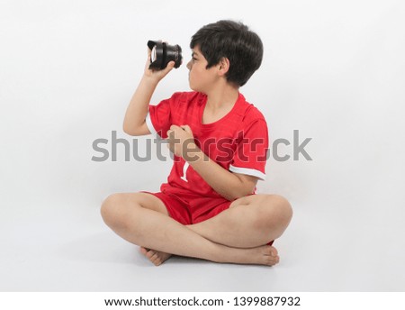 A boy looking through camera lens isolated on a white background
