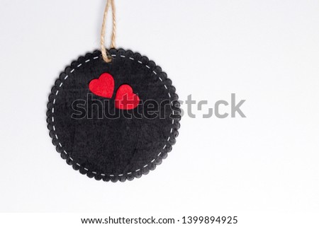 Round black wooden frame with two felt red hearts, twine, white background. Valentine's, Love, Wedding concept. Top view, copy space, mock up