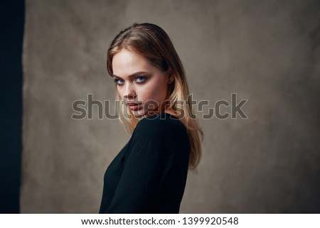 attractive female model in dark clothes on a textile background                            