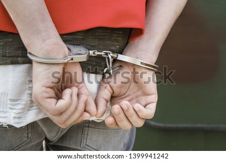 A man being arrested and handcuffed. Law enforcement, detention, crime concept.  Royalty-Free Stock Photo #1399941242