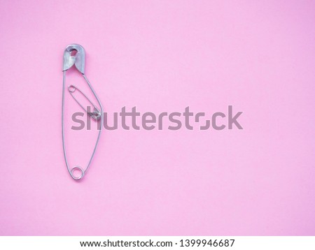 A safety pin representing a pregnant woman with a baby Royalty-Free Stock Photo #1399946687
