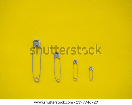 Several safety pins of different sizes. Concept of diversity and inclusion