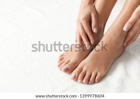 Woman with beautiful feet on white towel, closeup. Spa treatment Royalty-Free Stock Photo #1399978604