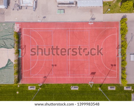 Aerial view of red football and basketball field.