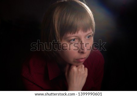 Portrait of ugly but sweet girl with chubby cheeks and dark background. Photo shoot of middle-aged women in the Studio with interesting backlight