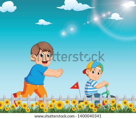 the boy is running to his brother who riding the bicycle in the garden