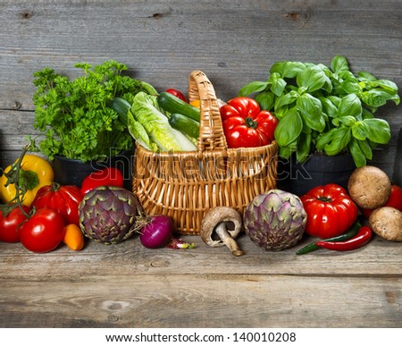 fresh herbs and vegetables on wooden background. raw food ingredients. country style picture. selective focus