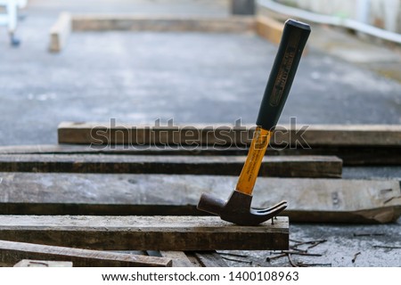 Photo of Hammer, rusty nail and wood for carpenter's job