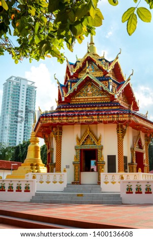 Photo of a buddhist temple in front of skyscrapers in George Town, Malaysia.