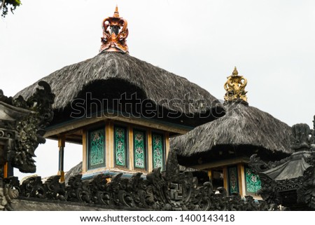 Beautiful family shrines in  Balinese Traditional Village. Reed roofing, golden crown. Each Hindu god (Brahma, Vishnu and Shiva) has own sacred temple within each household Penglipuran Bali Indonesia 