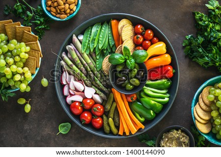 Party table setting with various veggie snacks, top down view on crudites plate and other vegetarian starters Royalty-Free Stock Photo #1400144090