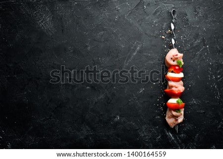 Raw chicken shish kebab with vegetables and spices. Top view. Free space for your text. Rustic style.