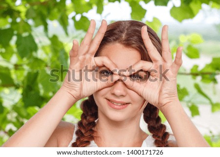 cheerful smiling girl shows hand gesture all OK in nature