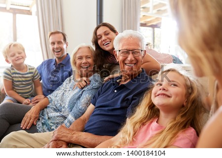 Multi-Generation Family Sitting On Sofa At Home Relaxing And Chatting Royalty-Free Stock Photo #1400184104