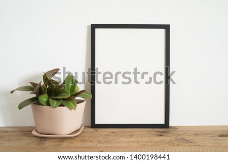 Black frame photo on table with plant at home
