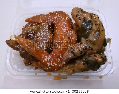 Hot and Spicy Chicken Wings in plastic containers.