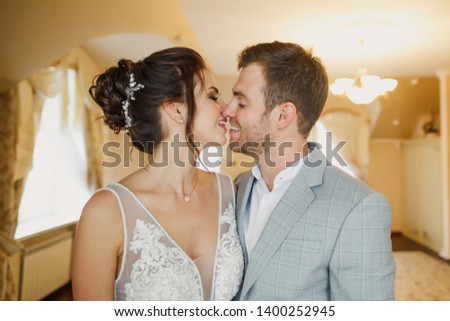 young beautiful wedding couple are standing in a bright room in the apartment