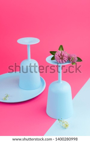 Plastic colored glasses for lunch in the open air. Crockery bright colors on a pink background
