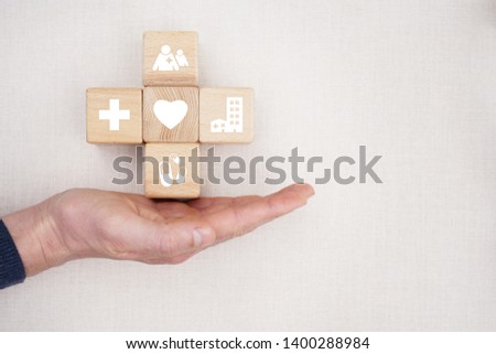 Doctor hand holds wood block stacking with icon healthcare medical, insurance for your health concept.