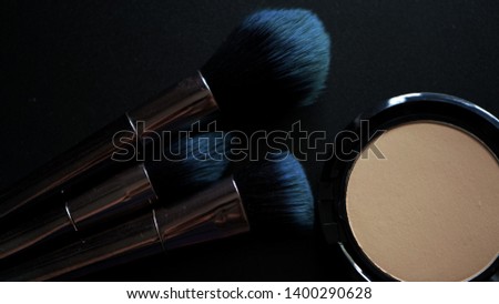  powder and makeup brushes on a black background                             