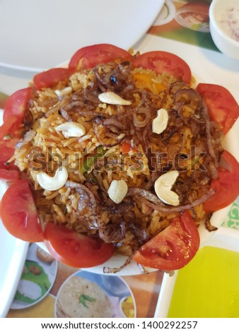 this is the picture of vegetable rice with onion, tomato, dry fruits . looks yummy