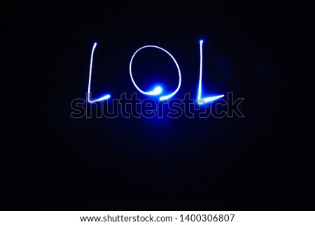 Word lol written with streaks of light led at lightpainting. Blue neon with black background