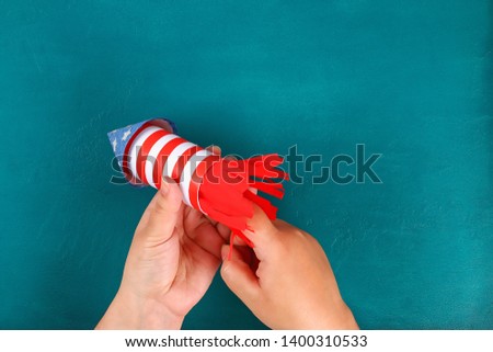 Diy 4th July petard toilet sleeve, paper, cardboard color American flag red blue white. Gift idea decor July 4, USA Independence Day. Step by step. Top view Process kid children craft. Workshop Royalty-Free Stock Photo #1400310533