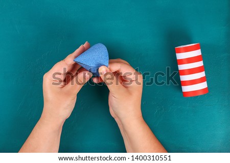 Diy 4th July petard toilet sleeve, paper, cardboard color American flag red blue white. Gift idea decor July 4, USA Independence Day. Step by step. Top view Process kid children craft. Workshop Royalty-Free Stock Photo #1400310551