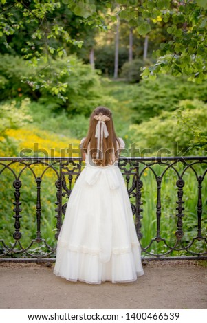 Little girl dressed in communion in a park