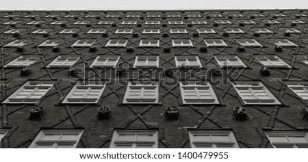 symmetry of windows and bricks with grey sky