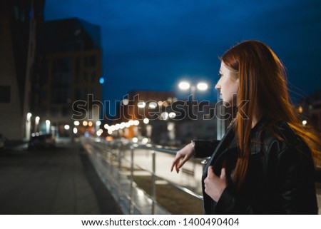 Stylish young woman standing in the night city. Dating, waiting, relaxing concept.